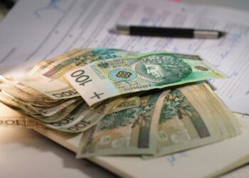 Stack of polish currency banknotes on papers.