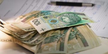 Stack of polish currency banknotes on papers.