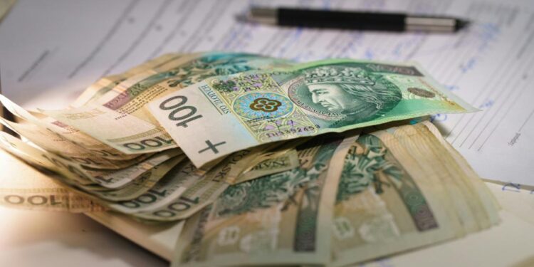 Stack of polish currency banknotes on papers.